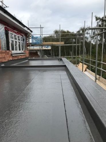 Flat roof under construction with scaffolding around the building.