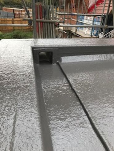 Close-up of a textured gray metal surface with a groove and a small rectangular opening.