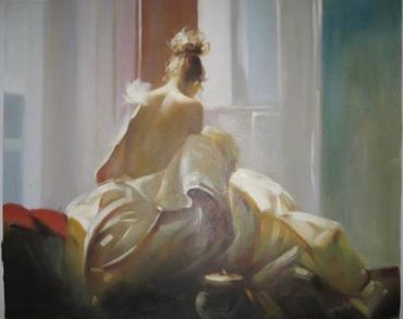 A woman with bare back sitting on a bed in soft natural light.