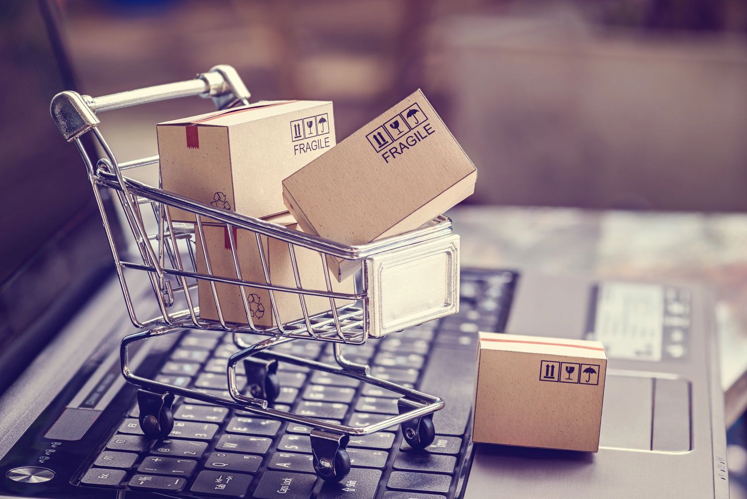 A tiny cart with tiny boxes on a laptop