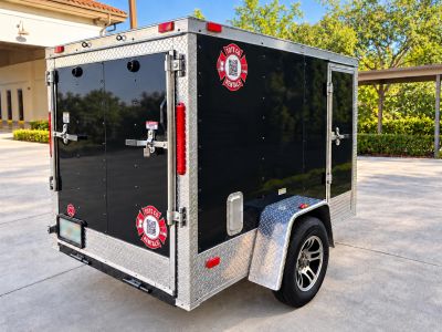 Black utility trailer with metal diamond plating and Tote Co Rentals logos.