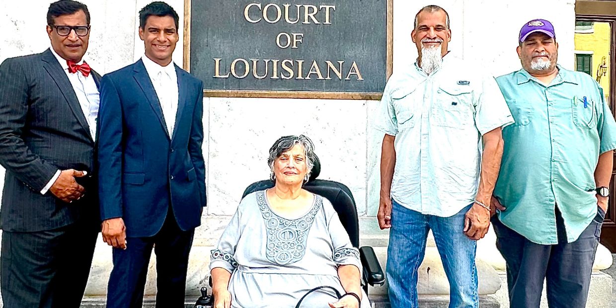 Group of five diverse adults posing outside the Supreme Court of Louisiana.