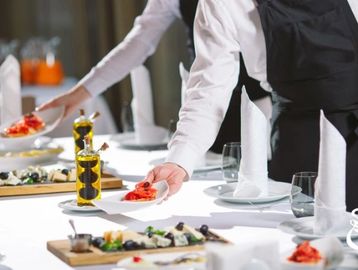 Waitstaff serving appetizers at a formal dining event.