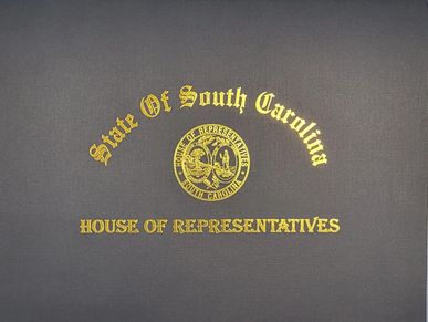 Seal and text of South Carolina House of Representatives on a wall.
