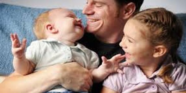 Father joyfully playing with his young children.