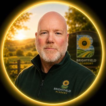 Portrait of a man in Brightfield Academy jacket with a sunset background.