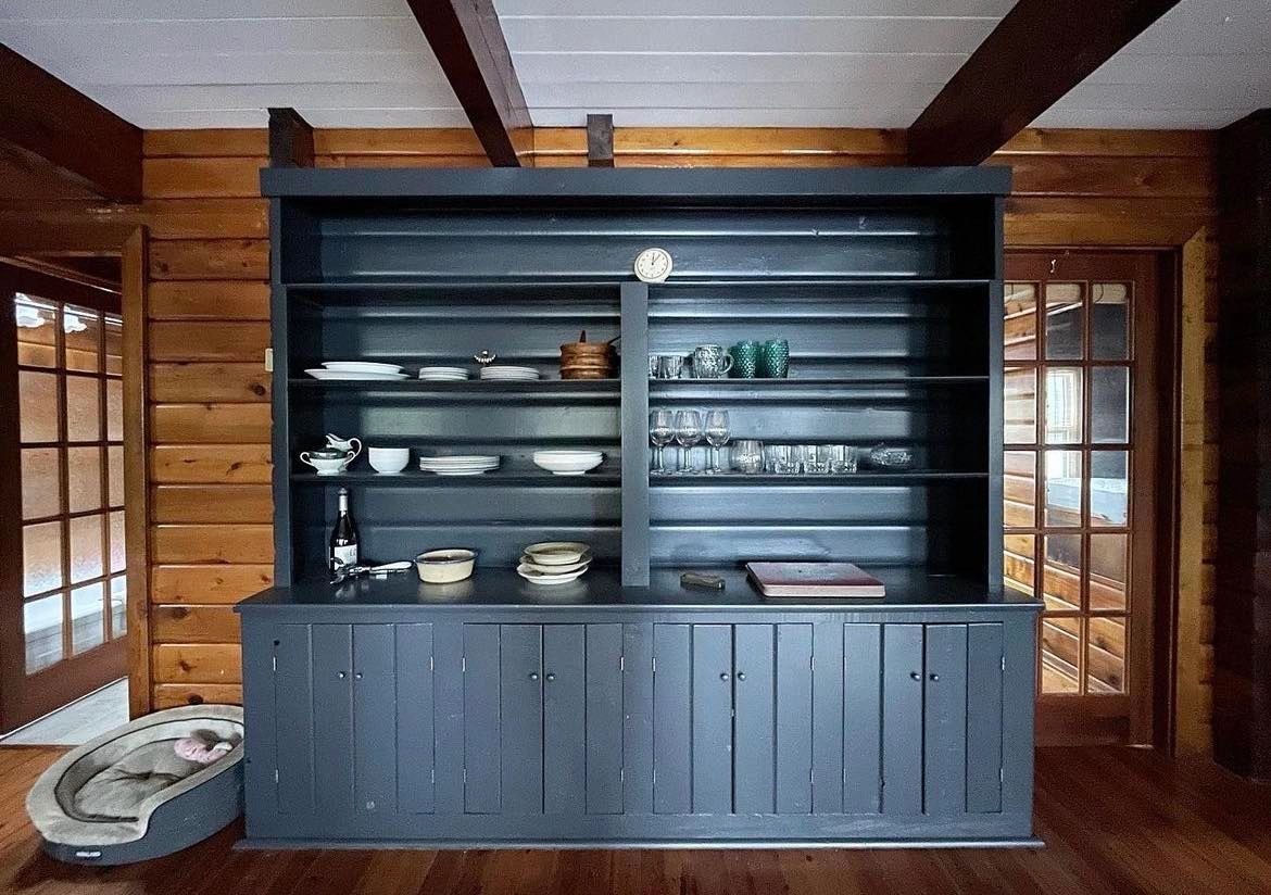 Painted wooden shelving unit in navy blue and painted wooden ceiling to white