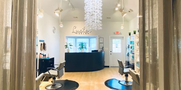 Salon space with desk, chairs and bubble chandelier.