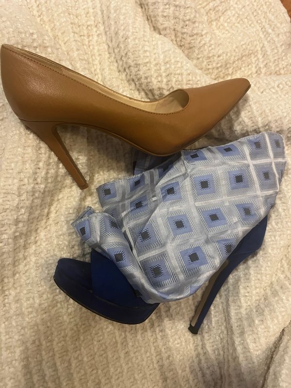 Pair of stylish high heels, one tan and one navy blue with patterned fabric.
