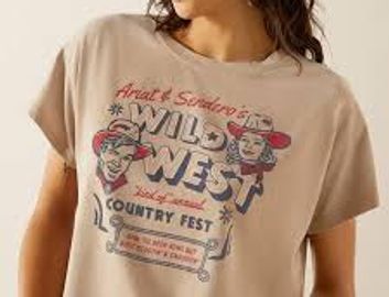 Woman wearing a beige t-shirt with a Wild West country fest graphic.