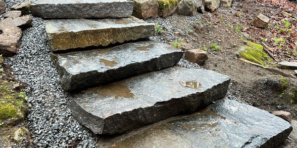 Natural stone steps with water puddles in an outdoor setting.