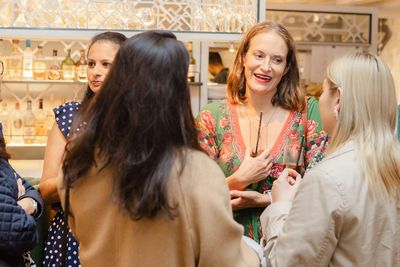 Women socializing and enjoying drinks at a social gathering.