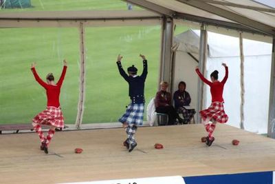 3 dancers competing in the sword dance at Cowal Highland games