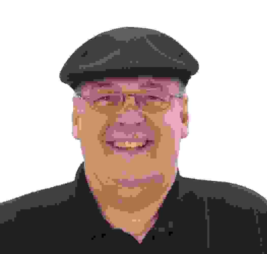 Chuck Wolf is wearing his black Kangol "Newsboy" hat and a black polo shirt.