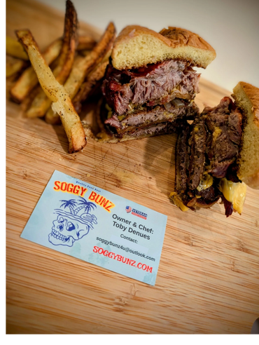 A sandwich and fries on top of a wooden cutting board.