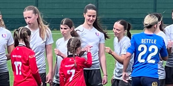 Young female soccer players shaking hands after a match.