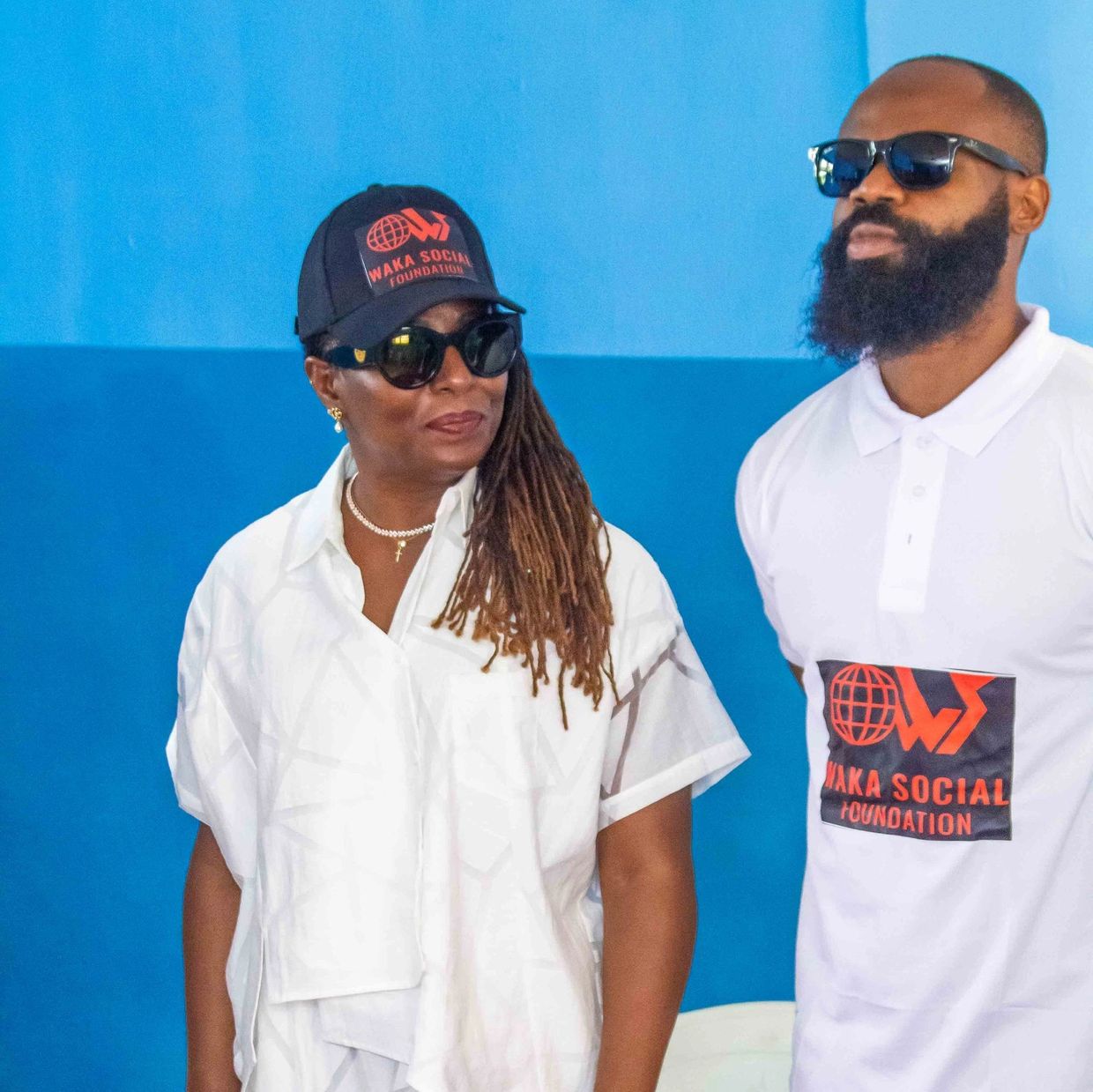 Two people wearing Waka Social Foundation apparel and sunglasses.