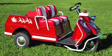 Festive red golf cart with Santa and reindeer decals.