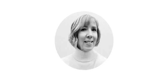 Black and white portrait of a smiling woman with short hair in a turtleneck.