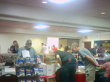 People browsing and shopping at an indoor market or convention.