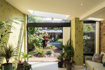 Open bi-fold doors connecting the Newham extension's living space with the garden.