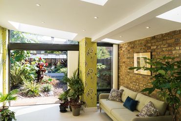 Rooflights and rear glazing bring daylight into the extended living space in Newham.
