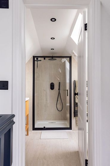 View through the Brentwood loft bathroom towards the black-framed shower enclosure.