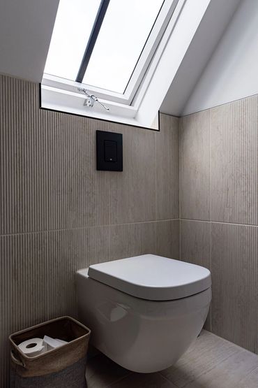 Wall-hung WC beneath a rooflight in the Brentwood loft bathroom.