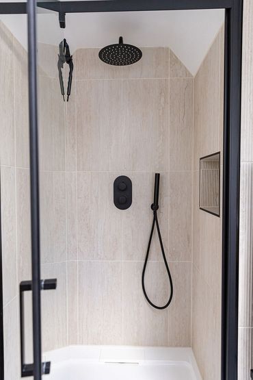 Black-framed shower enclosure with matching black shower fittings in the loft bathroom.