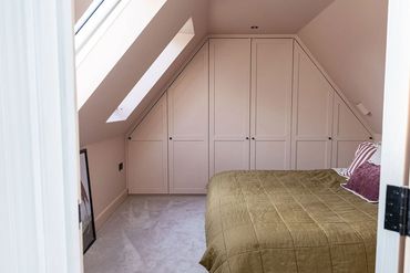 Brentwood loft bedroom with fitted wardrobes following the roof slopes.