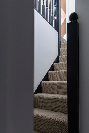 New carpeted staircase with dark timber handrail leading to the Brentwood loft suite.