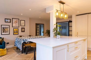 Open-plan family room with kitchen island, dining table and separate seating area.
