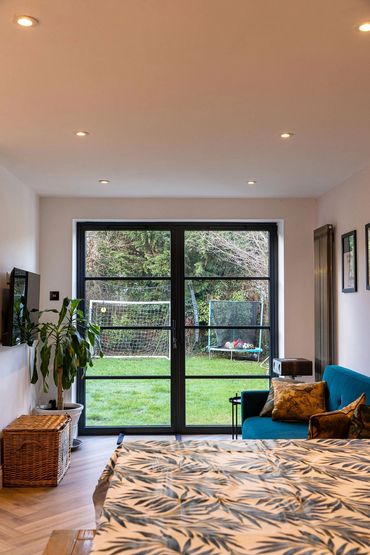 Family seating area with black garden doors opening onto the rear garden.