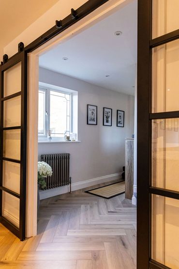 Black-framed internal doors connecting the hallway with the new family room.