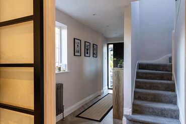 Remodelled hallway with black-framed internal doors and a newly finished staircase.