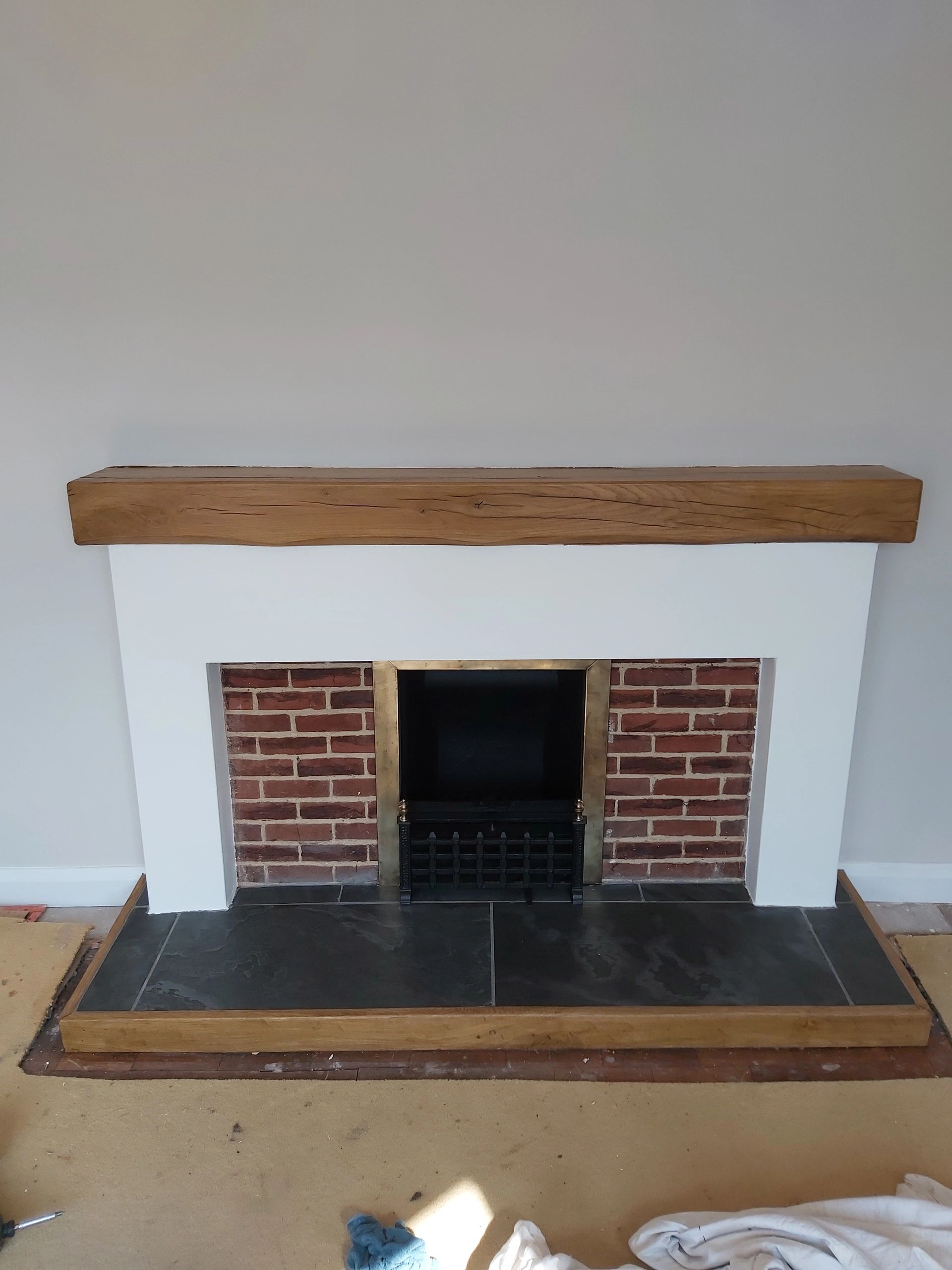 Tiled slate hearth with oak surround , solid oak mantel fitted. Existing fireplace reduced in size p
