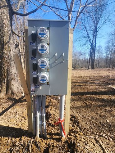 Electric meter box outdoors in a wooded area.