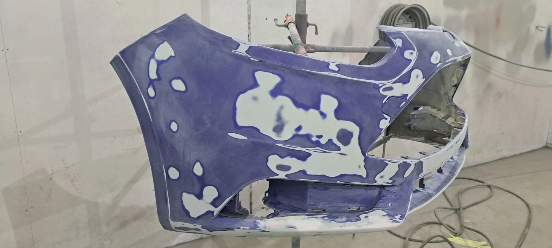 Car bumper being sanded and prepped for painting.