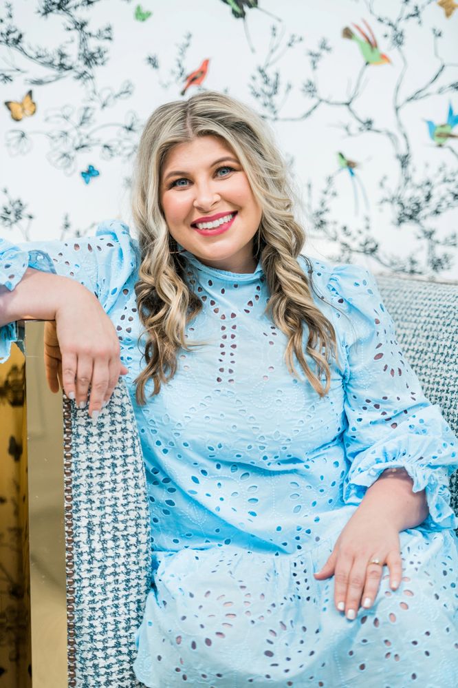 Ashlee Erlinger of Love Lead Inspire smiles while wearing a blue eyelet dress.