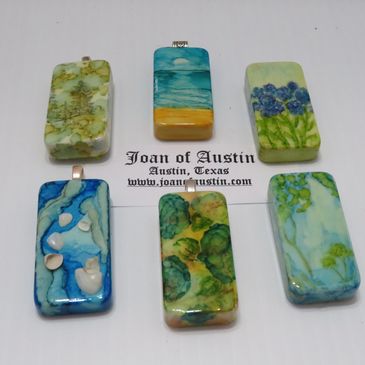 Samples of Alcohol Ink on Dominoes to be worked into necklaces or worn as pendants.
