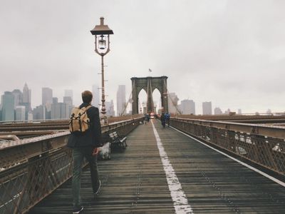 Pedestrians walking across a long suspension walking path bridge