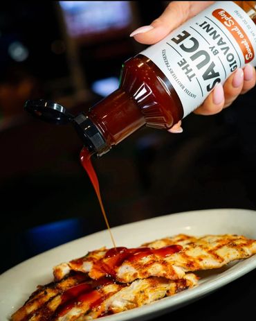 SANTISI BROTHERS The Sauce by Giovanni bottle poured over grilled chicken breasts