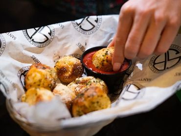 SANTISI BROTHERS basket of garlic knots served with house-made tomato sauce