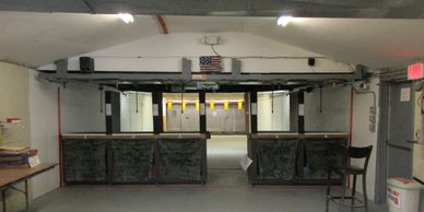 Indoor shooting range with target lanes and protective barriers.