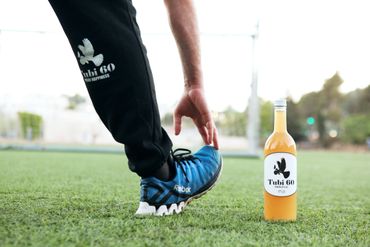 Tubi 60 bottle on turf with man stretching