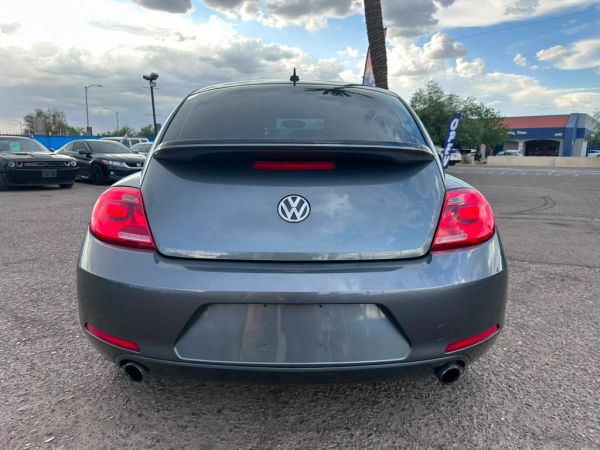 Rear view of a gray Volkswagen car in a parking lot.