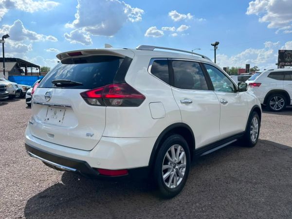 White SUV parked outside under a partly cloudy sky.