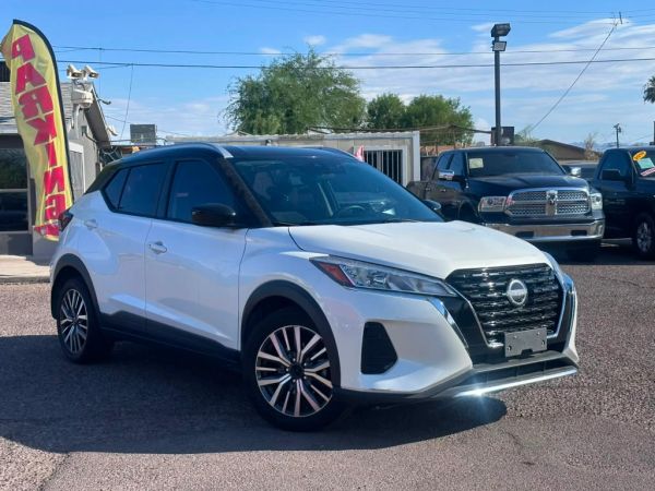 White Nissan SUV parked outdoors on sunny day.