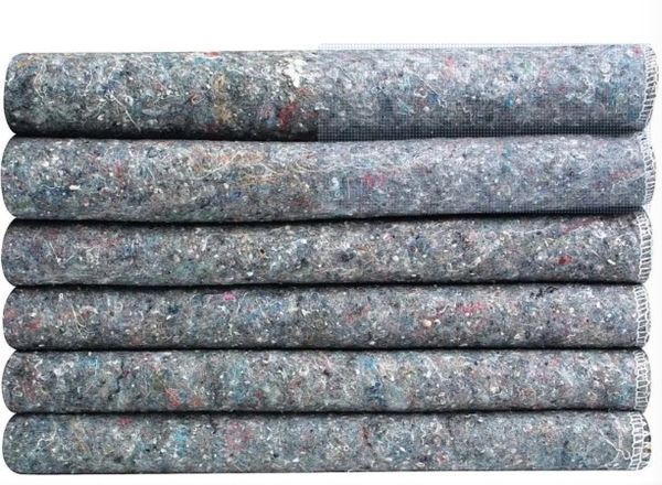 Stack of rolled, textured fabric or padding material with mixed colors.