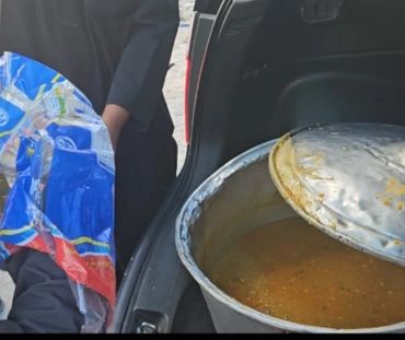 Large pot of soup or stew being transported in car trunk.